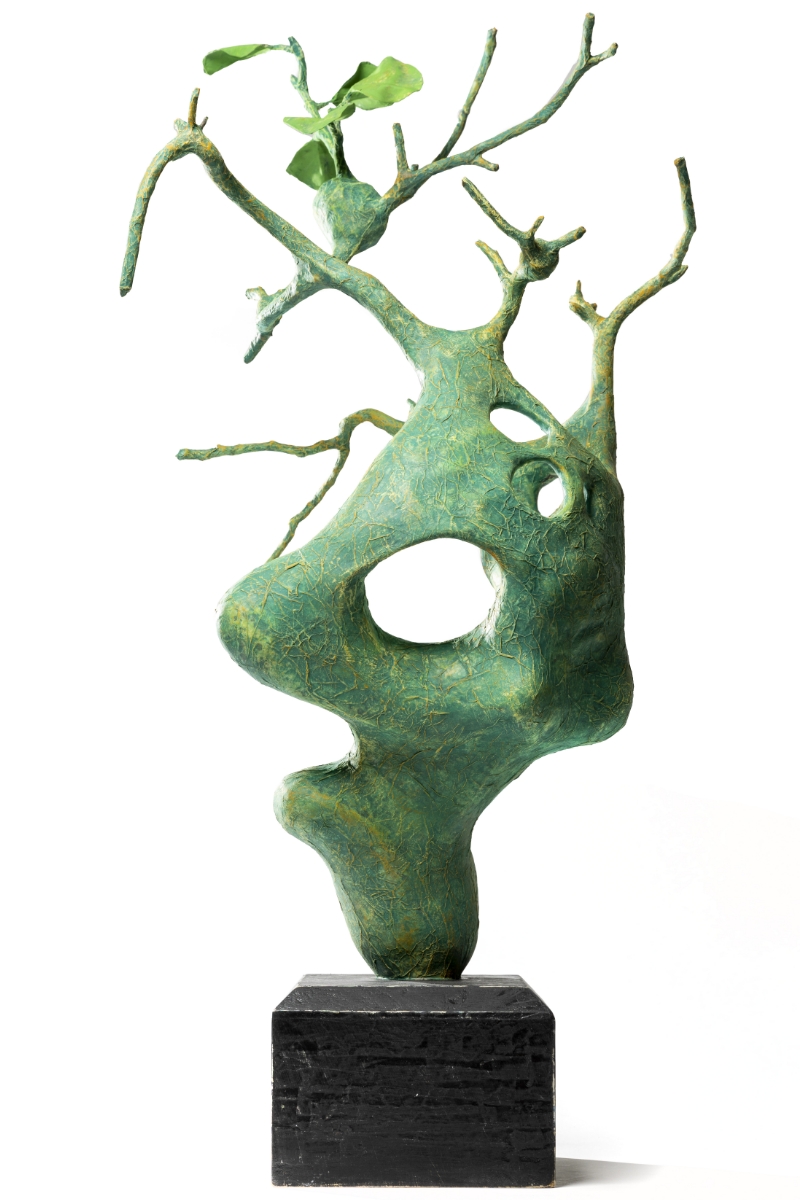 Green abstract sculpture with branches and leaves on a black base