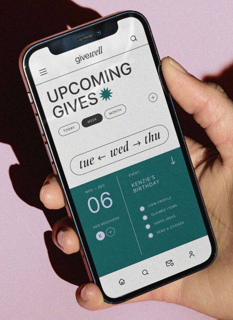 A hand holds a smartphone displaying the givewall app with event details for "Kenzie's Brithday"