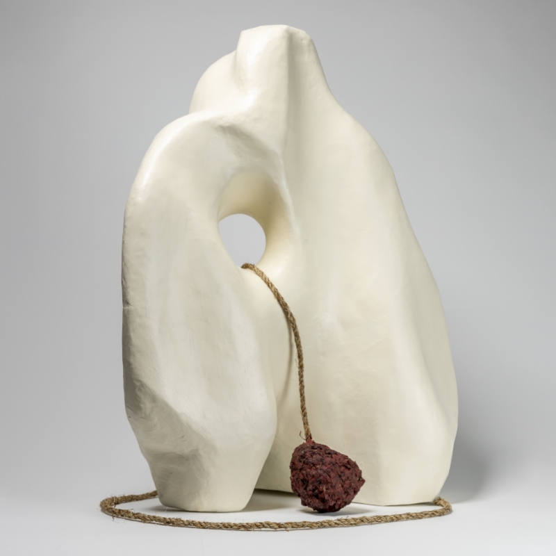 Abstract cream-colored sculpture with a rock tied to a rope.