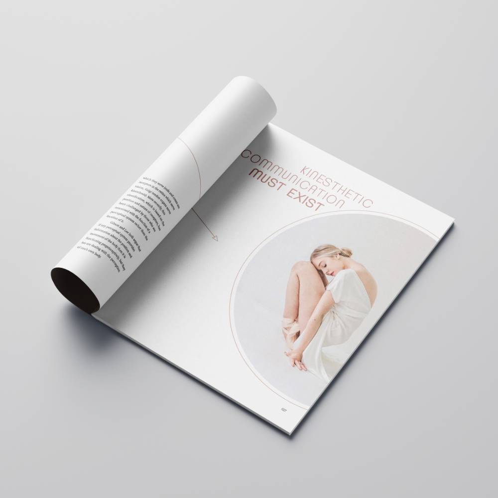 Open magazine on a gray surface with a circular image of a woman and text.              