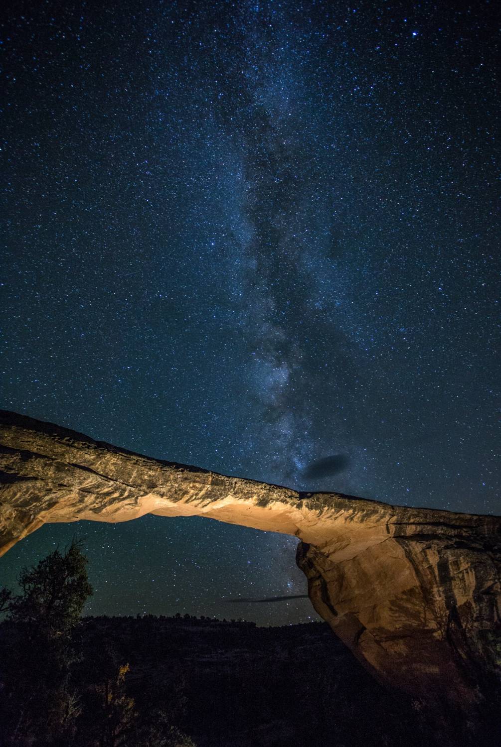 A stone arch under a starry night sky with the Milky Way visible.              