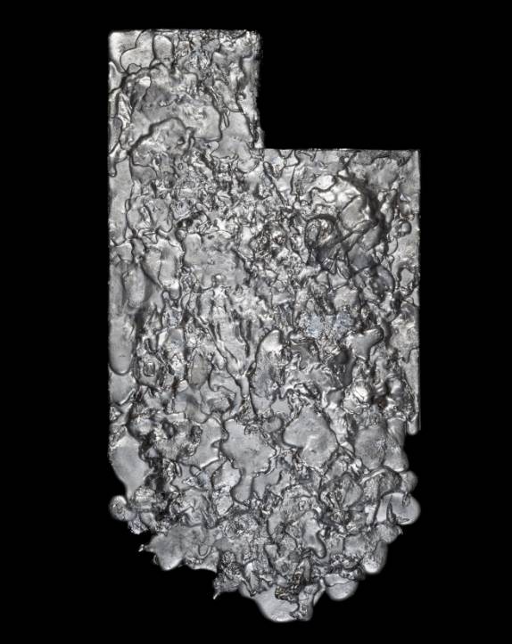 Textured metallic object resembling the shape of Utah on a black background.              