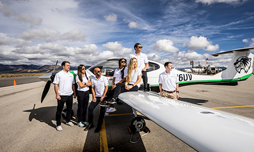students around an airplane looking into the distance