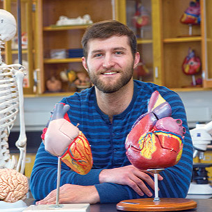 man sitting behind some heart diaramas