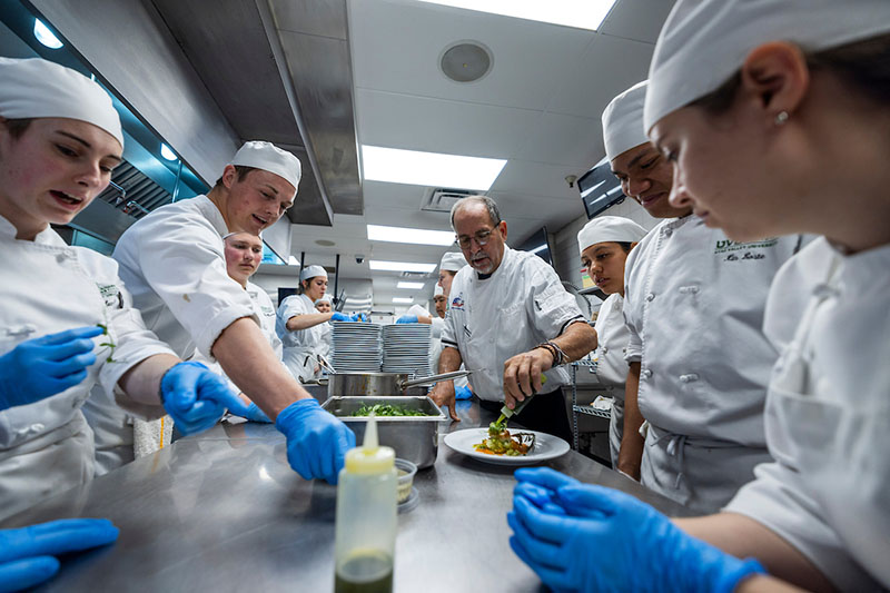 烹饪艺术 students surrounding a table preparing dishes