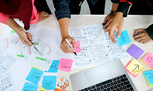 group of people looking over design notes