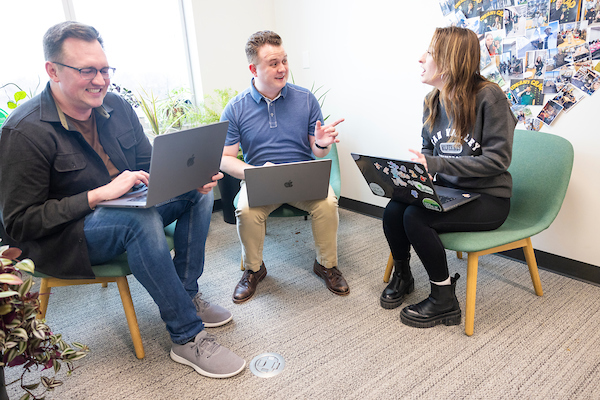People with laptops having a discussion