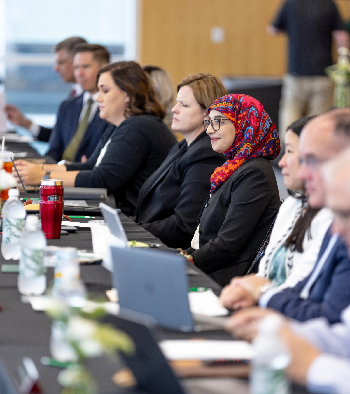 Group of people sitting at a conference table.