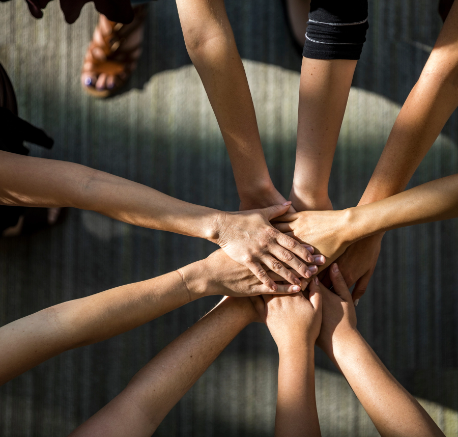 Hands stacked on top of each other in all-in gesture.