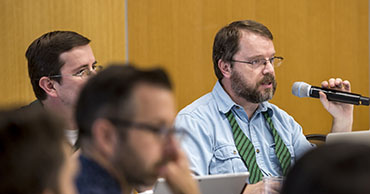 An executive committee member speaking into a microphone