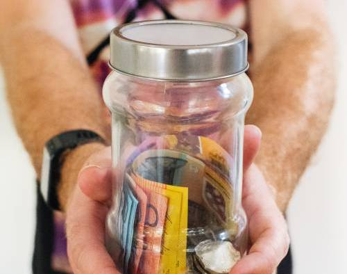 Jar of paper bills held in both hands