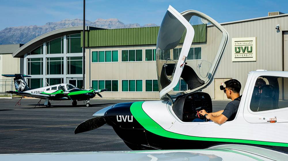 student sitting in UVU plane and going through routine pre flight checks