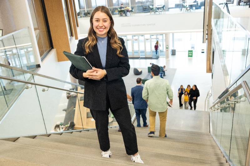 business graduate student posing for picture on stairs