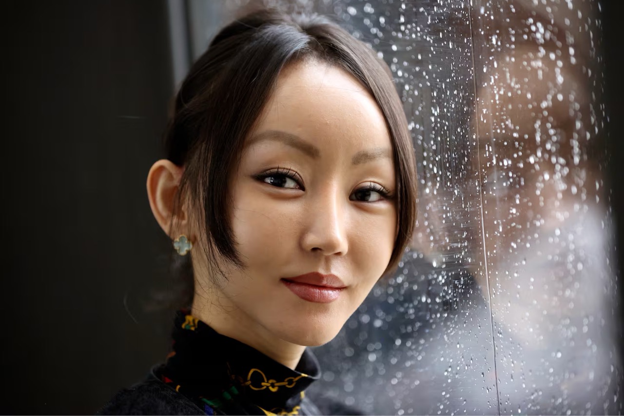 Yeonmi Park profile shot in front of a window with water on it.