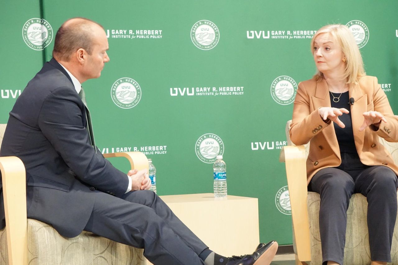 Mike Lee and Liz Truss speaking at UVU with 赫伯特学院 background