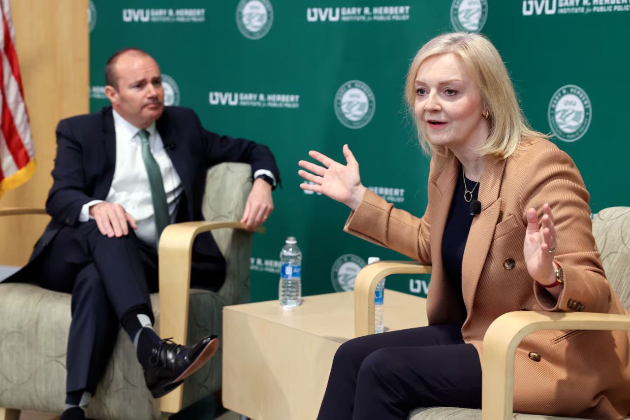 Liz Truss speaking at UVU with Mike Lee sitting in the background