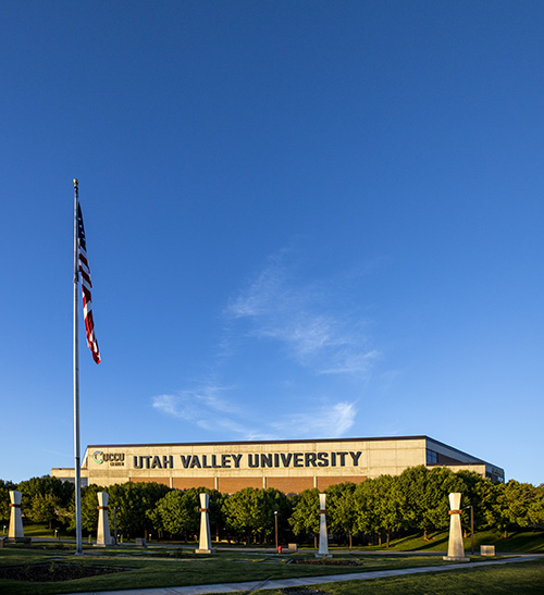 犹他谷大学 signage on building with an American flag in front