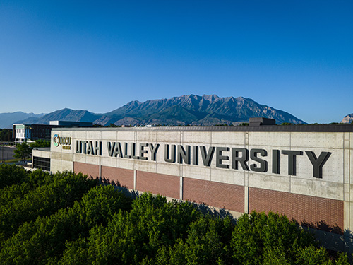 犹他谷大学 signage on a building with a mountain in the background