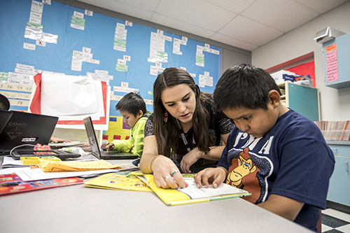 A teacher helping a student with work