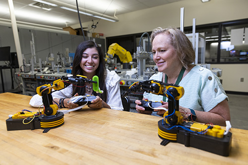 Two 工程 students use robotic arms.