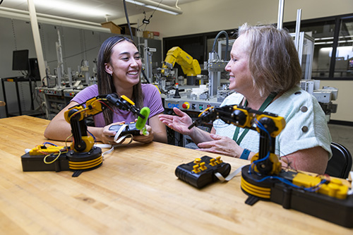 Two 工程 students use robotic arms.