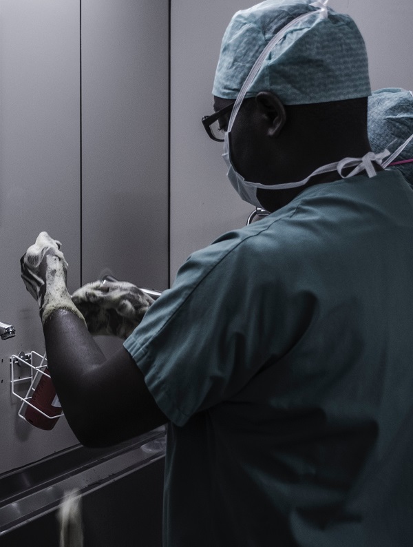 A woman puts on gloves in a nurse uniform