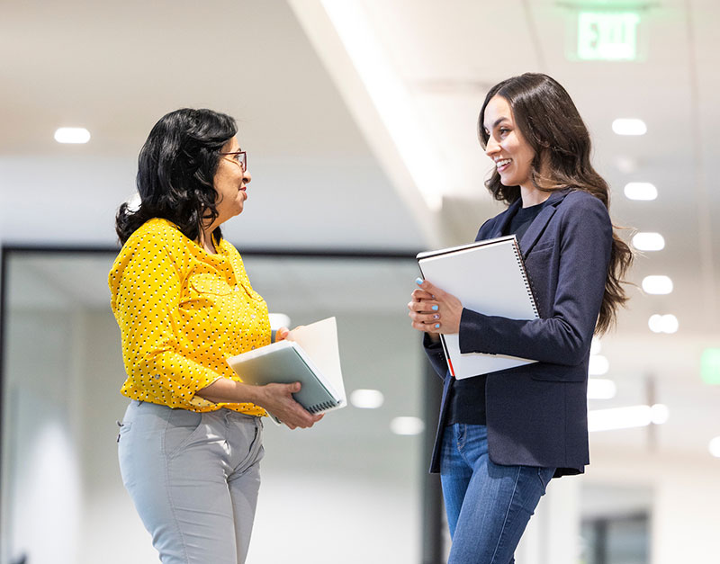 2 women talking in the hallway