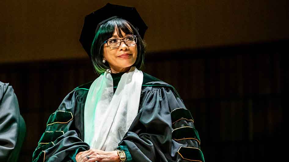 President Tuminez sitting at commencement.