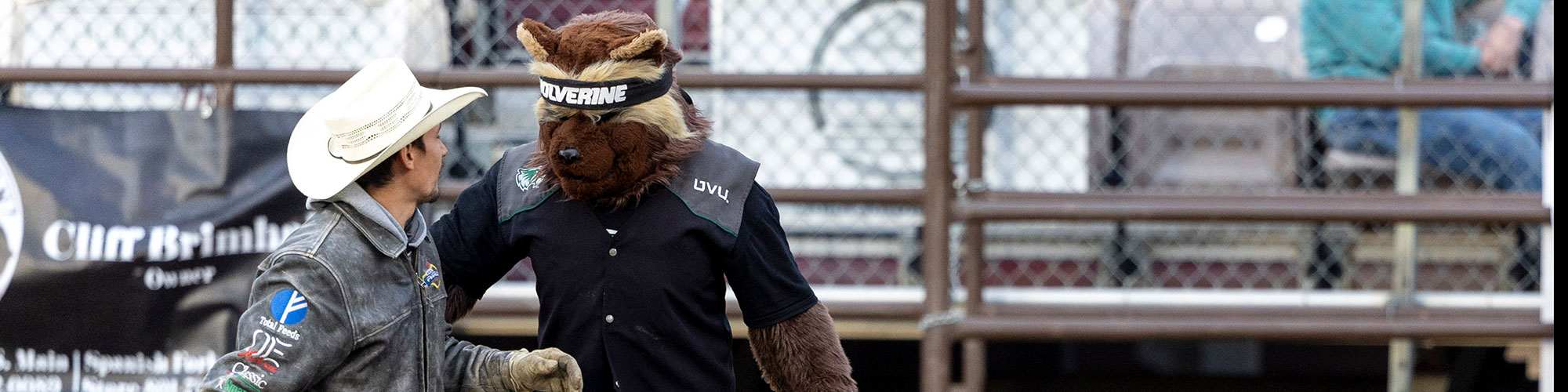 UVU竞技 college athlete talking to the UVU mascot, Willie the Wolverine