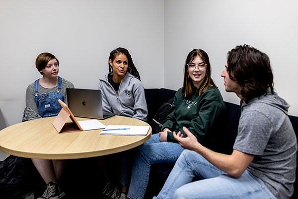 4 people discussing something at a table