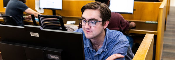 A student studying at a desktop computer.