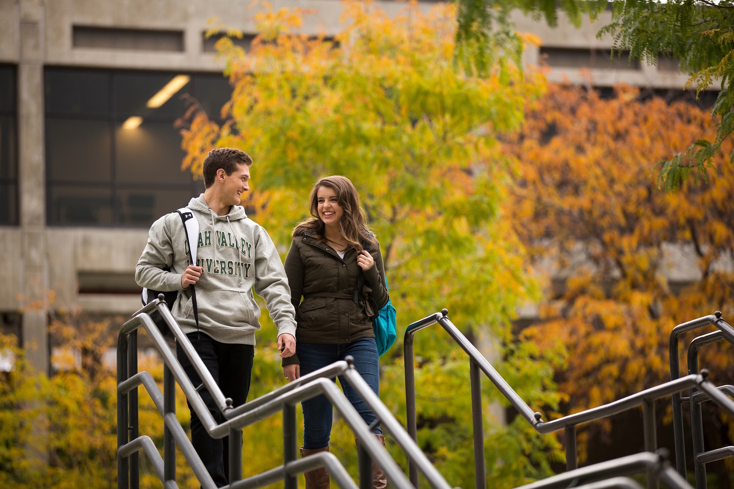 学生s walking down the stairs outside of UVU in autumn