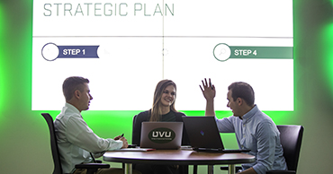 group working through a strategic plan that is projected on the wall behind them